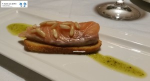 Crostino con salmone e pinoli su salsa al pistacchio