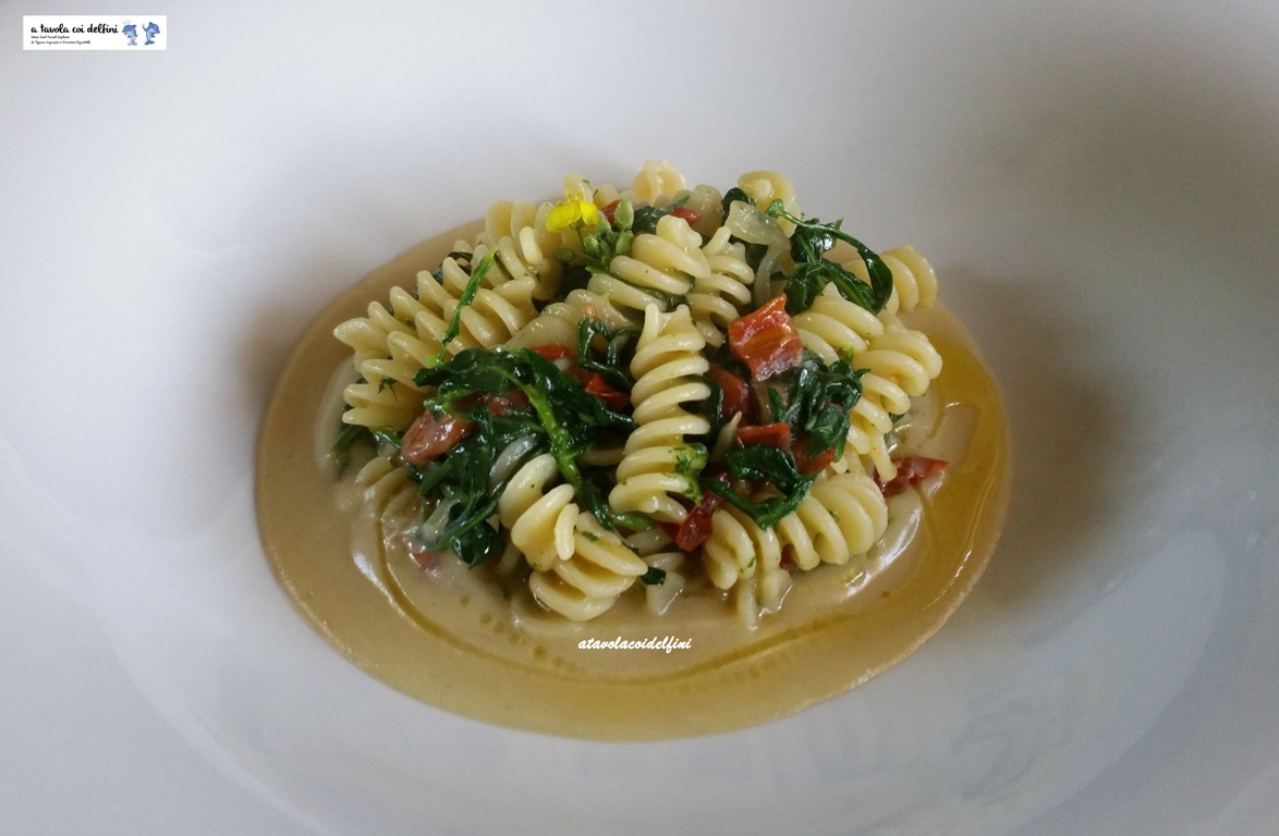 Fusilli alla rucola selvatica, cipolla di Acquaviva e pomodori secchi su crema di fave secche