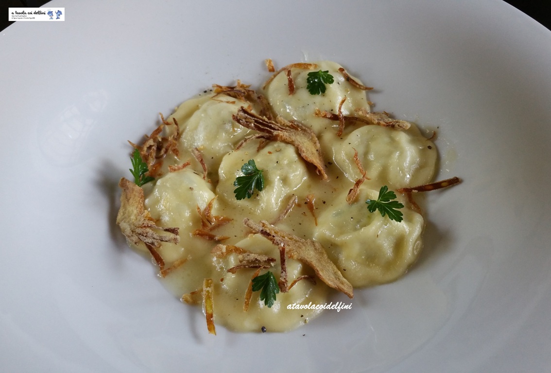 Ravioli ripieni di ricotta e carciofi con carciofi fritti su salsa al parmigiano