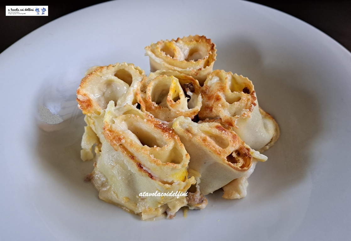 Rosette di pasta fresca ripiene di zucca e salsiccia con besciamella e parmigiano